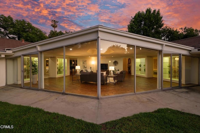 3505 E California Blvd, Pasadena, CA 91107 - back of property at dusk with a patio, a sunroom, and a tile roof