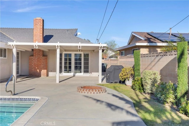 12111 Reagan St, Los Alamitos, CA 90720 - back of house with a chimney, a patio area, roof with shingles, and an outdoor pool