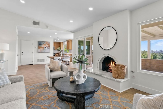 23631 Via Storni, Mission Viejo, CA 92692 - living area featuring wood finished floors, lofted ceiling, a warm lit fireplace, and recessed lighting