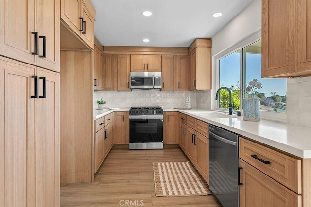 23631 Via Storni, Mission Viejo, CA 92692 - kitchen featuring appliances with stainless steel finishes, light wood-type flooring, light countertops, decorative backsplash, and recessed lighting