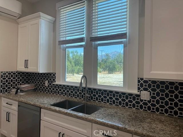 1902 E Citrus Ave, Redlands, CA 92374 - kitchen with an AC wall unit, dishwashing machine, white cabinets, light stone countertops, and tasteful backsplash