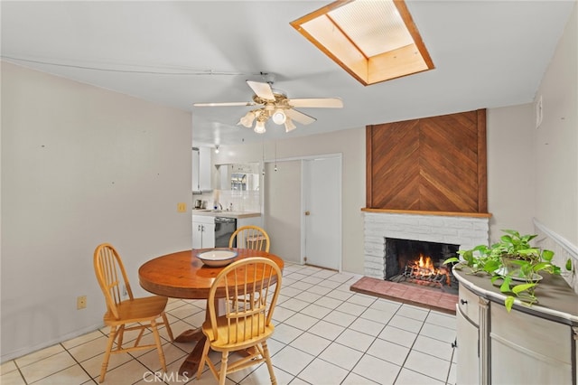 932 Redwood Ct, Corona, CA 92879 - dining room featuring light tile patterned floors, a ceiling fan, a fireplace, and a skylight