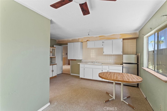 932 Redwood Ct, Corona, CA 92879 - kitchen featuring freestanding refrigerator, a ceiling fan, white cabinets, light countertops, and decorative backsplash
