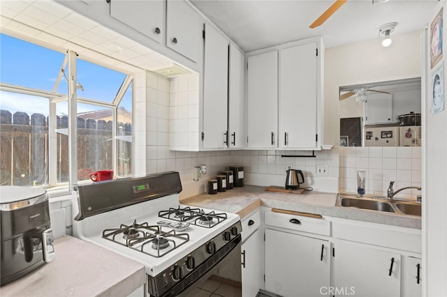 932 Redwood Ct, Corona, CA 92879 - kitchen featuring white range with gas cooktop, a ceiling fan, backsplash, and white cabinetry