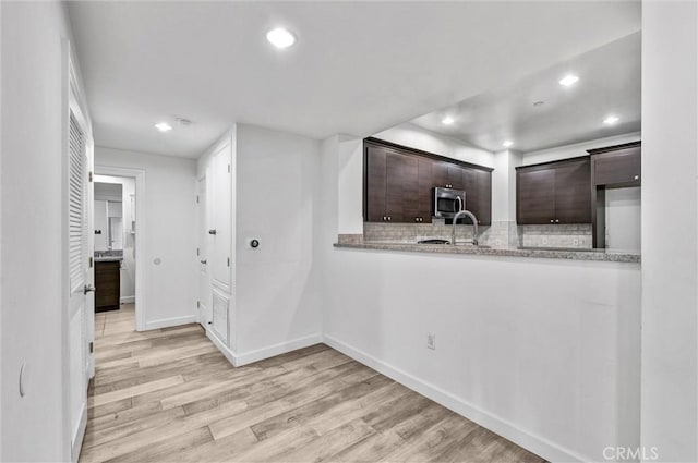 991 Arapahoe St Unit 202A, Los Angeles, CA 90006 - kitchen with stainless steel microwave, decorative backsplash, recessed lighting, light wood finished floors, and dark brown cabinetry