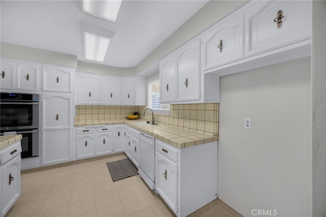 10802 Jordan Rd, Whittier, CA 90603 - kitchen with stainless steel double oven, dishwasher, and white cabinets