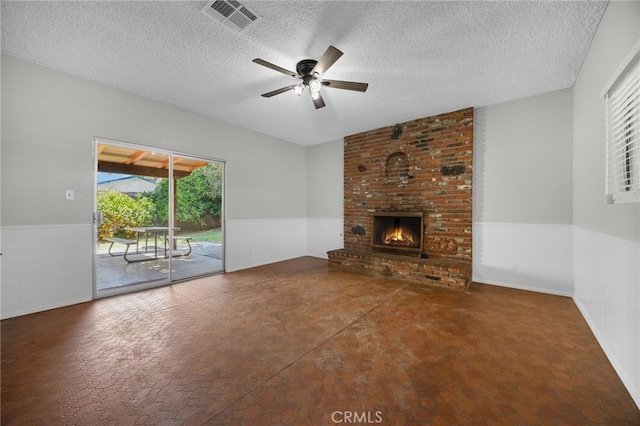 10802 Jordan Rd, Whittier, CA 90603 - unfurnished living room featuring a textured ceiling, a wainscoted wall, a ceiling fan, and a brick fireplace