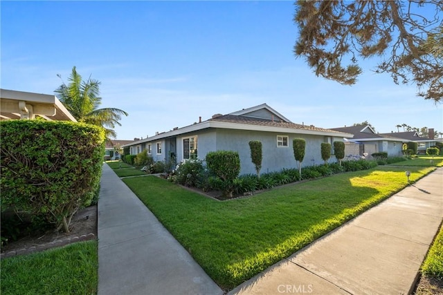 1076 Mitchell Ave, Tustin, CA 92780 - view of side of property featuring stucco siding, a lawn, and a residential view