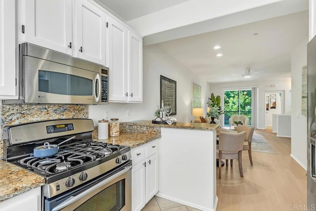 1131 Elfin Forest Rd E, San Marcos, CA 92078 - kitchen featuring stainless steel appliances, white cabinetry, light stone counters, open floor plan, and recessed lighting