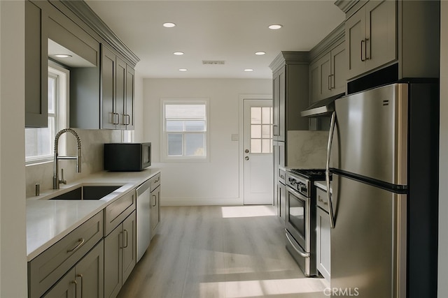 13132 Stanrich Pl, Garden Grove, CA 92843 - kitchen with stainless steel appliances, under cabinet range hood, decorative backsplash, light countertops, and light wood-style flooring