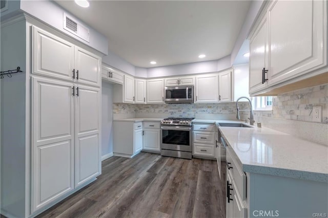 9000 Vanalden Ave Unit 176, Northridge, CA 91324 - kitchen with appliances with stainless steel finishes, white cabinetry, dark wood finished floors, tasteful backsplash, and recessed lighting