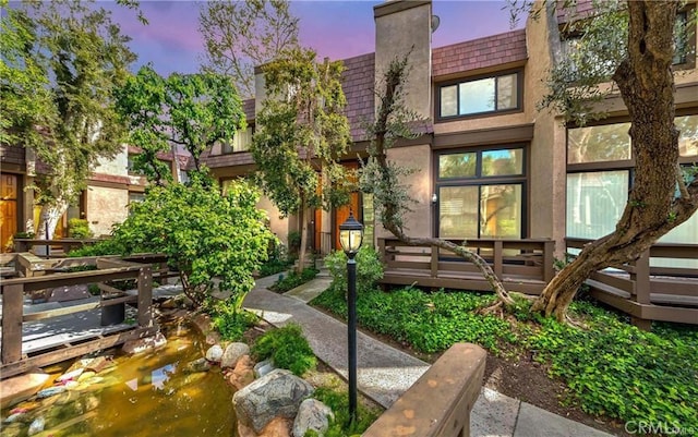 9000 Vanalden Ave Unit 176, Northridge, CA 91324 - view of front facade featuring mansard roof, stucco siding, a chimney, and a deck