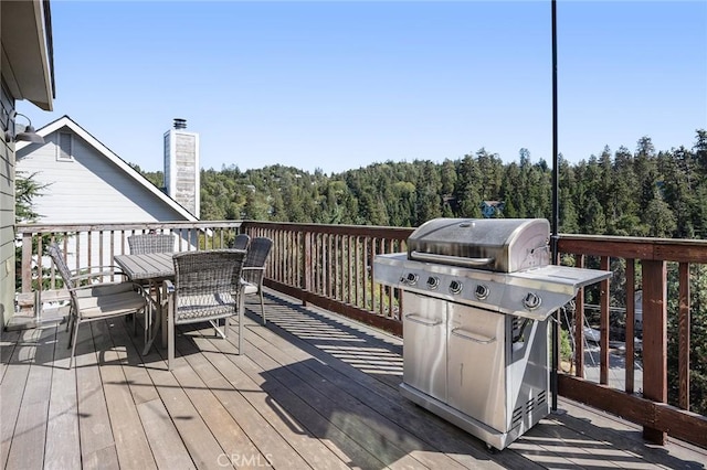26845 Modoc Ln, Lake Arrowhead, CA 92352 - deck featuring area for grilling, outdoor dining space, and a forest view