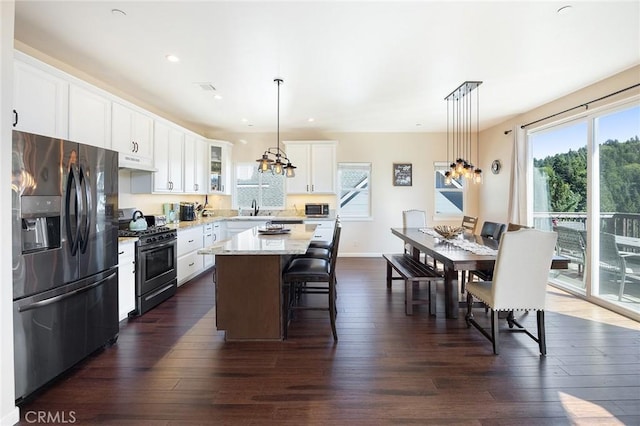 26845 Modoc Ln, Lake Arrowhead, CA 92352 - kitchen with stainless steel fridge, gas range oven, under cabinet range hood, a kitchen island, and a kitchen bar