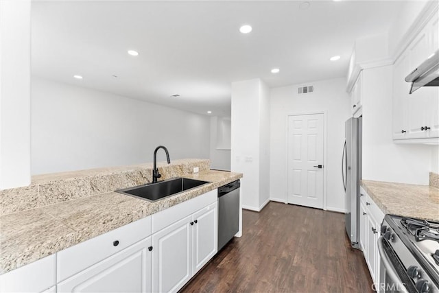 456 W Linden Dr, Orange, CA 92865 - kitchen featuring appliances with stainless steel finishes, white cabinetry, dark wood-type flooring, recessed lighting, and wall chimney exhaust hood