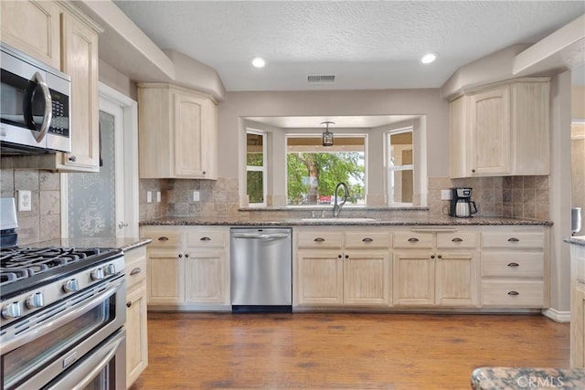 9525 Cambria Ct, Phelan, CA 92371 - kitchen with stainless steel appliances, backsplash, wood finished floors, a textured ceiling, and recessed lighting