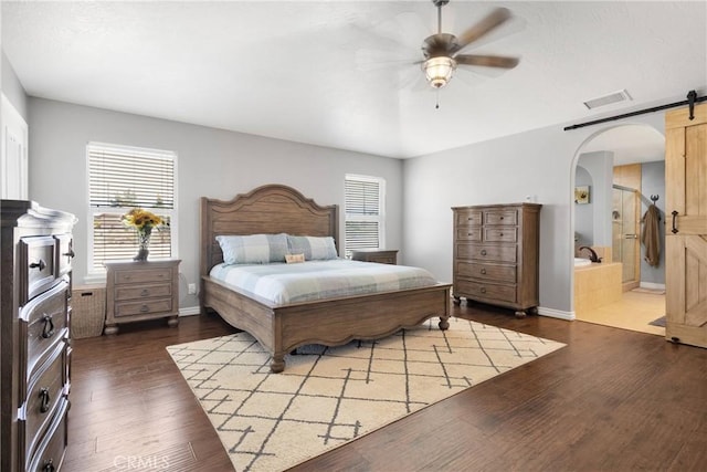 9525 Cambria Ct, Phelan, CA 92371 - bedroom with arched walkways, dark wood-type flooring, a barn door, ensuite bath, and a ceiling fan
