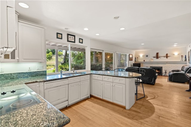 5230 Harbour Heights Ct, San Diego, CA 92109 - kitchen with electric stovetop, white cabinetry, a warm lit fireplace, open floor plan, and recessed lighting