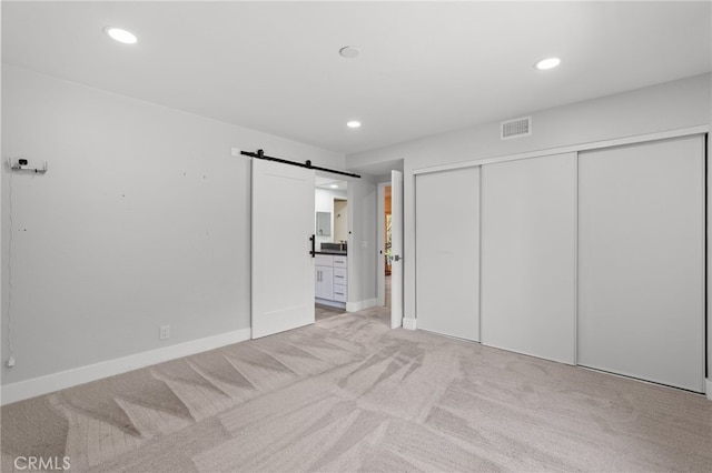 5230 Harbour Heights Ct, San Diego, CA 92109 - unfurnished bedroom featuring a barn door, light colored carpet, recessed lighting, a closet, and connected bathroom