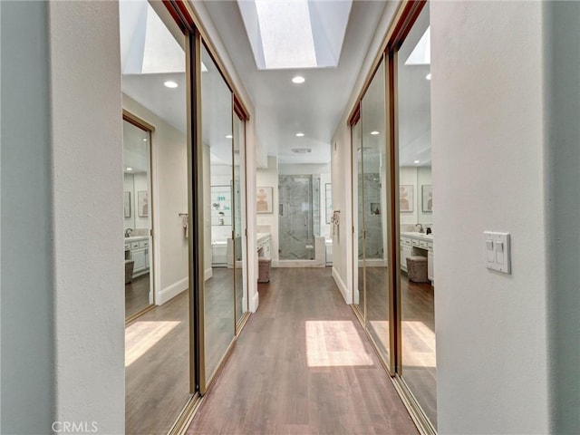 23034 Park Este, Calabasas, CA 91302 - hall with wood finished floors, a skylight, and recessed lighting