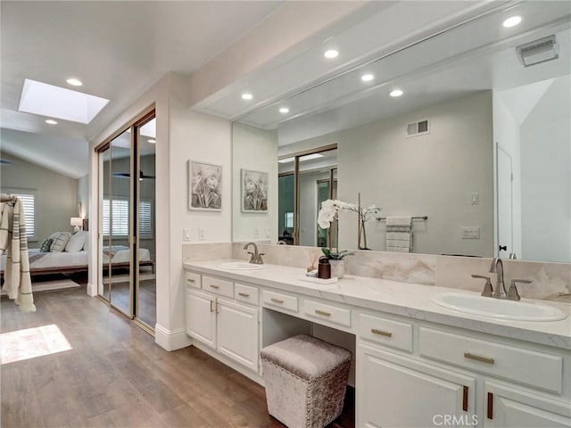 23034 Park Este, Calabasas, CA 91302 - full bathroom with a skylight, ensuite bath, recessed lighting, double vanity, and wood finished floors