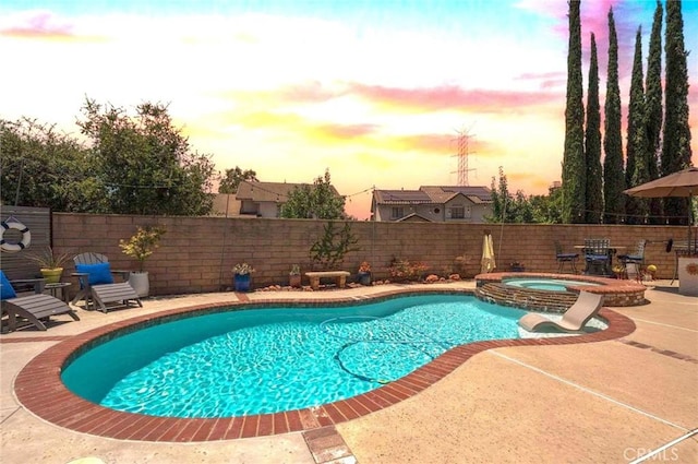 6140 Meadow Lark Dr, La Verne, CA 91750 - pool at dusk featuring a pool with connected hot tub, a patio area, and a fenced backyard