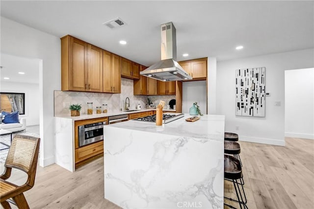 57 S Grand Oaks Ave, Pasadena, CA 91107 - kitchen featuring island range hood, appliances with stainless steel finishes, light wood-style flooring, backsplash, and recessed lighting
