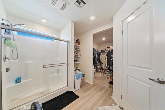 16814 Desert Star St, Victorville, CA 92394 - bathroom with a stall shower, wood finished floors, a spacious closet, and recessed lighting