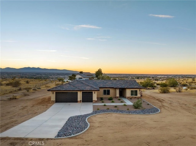 11228 Mockingbird, Apple Valley, CA 92308 - view of front facade with concrete driveway, an attached garage, stucco siding, a mountain view, and a tile roof