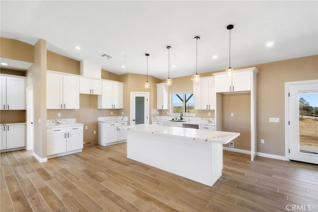 11228 Mockingbird, Apple Valley, CA 92308 - kitchen with a center island, white cabinets, light wood-type flooring, pendant lighting, and lofted ceiling