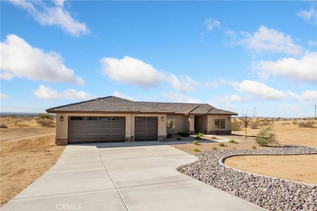 11228 Mockingbird, Apple Valley, CA 92308 - view of front of house with an attached garage, concrete driveway, stucco siding, stone siding, and a tile roof