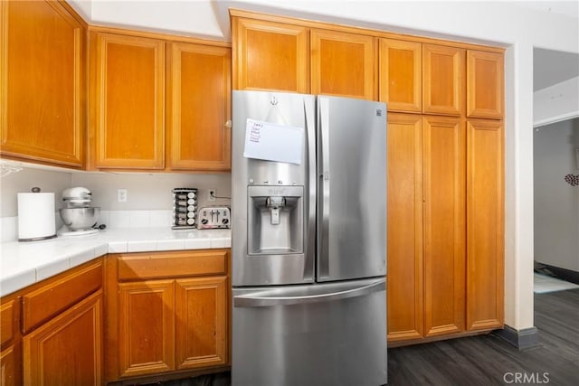26 Billings Ave, Beaumont, CA 92223 - kitchen featuring stainless steel refrigerator with ice dispenser, dark wood-style floors, tile counters, and brown cabinetry