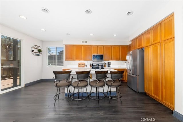 26 Billings Ave, Beaumont, CA 92223 - kitchen with stainless steel appliances, light countertops, a kitchen breakfast bar, dark wood finished floors, and recessed lighting