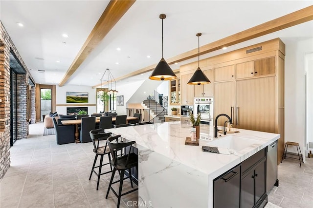 1831 Newport Hills Dr E, Newport Beach, CA 92660 - kitchen featuring beam ceiling, open floor plan, a spacious island, a warm lit fireplace, and light stone countertops
