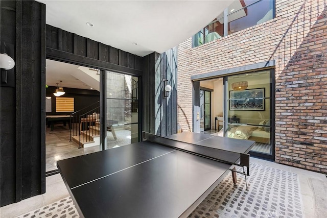 1831 Newport Hills Dr E, Newport Beach, CA 92660 - playroom with brick wall, a towering ceiling, and tile patterned flooring