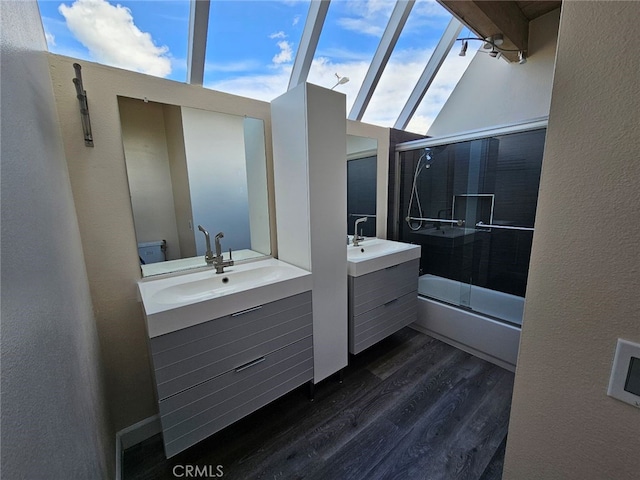 400 Monterey Rd Unit 10, Glendale, CA 91206 - full bath featuring wood finished floors, enclosed tub / shower combo, two vanities, and a textured wall