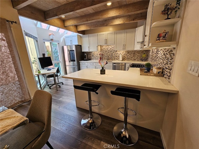 400 Monterey Rd Unit 10, Glendale, CA 91206 - kitchen with appliances with stainless steel finishes, a peninsula, light countertops, dark wood-style flooring, and decorative backsplash