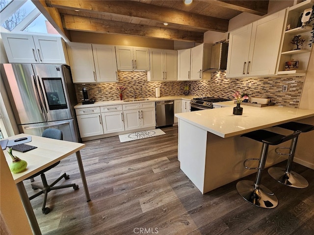 400 Monterey Rd Unit 10, Glendale, CA 91206 - kitchen with stainless steel appliances, wall chimney range hood, dark wood-style flooring, a peninsula, and a wooden ceiling with exposed beams