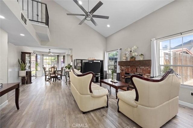 3108 Holbrook St, Bakersfield, CA 93312 - living room featuring a ceiling fan, high vaulted ceiling, healthy amount of natural light, light wood-type flooring, and a fireplace