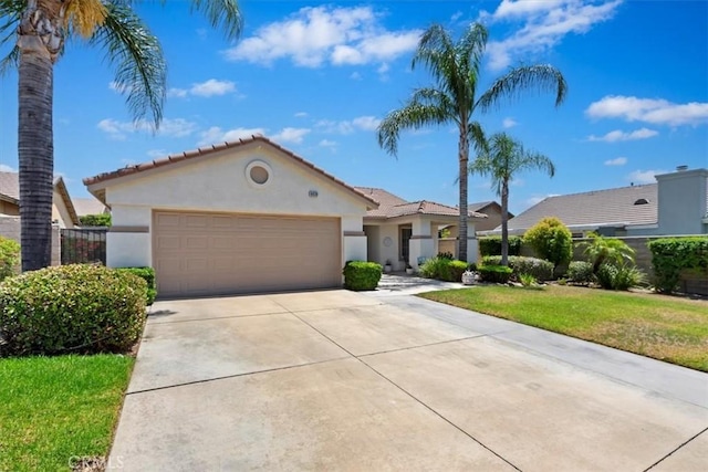 6939 Fremontia Ave, Fontana, CA 92336 - mediterranean / spanish home with an attached garage, stucco siding, driveway, a tiled roof, and a front lawn