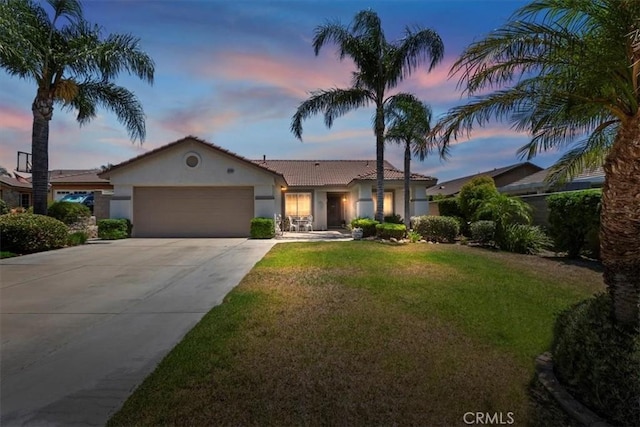 6939 Fremontia Ave, Fontana, CA 92336 - view of front of home featuring stucco siding, a garage, concrete driveway, a front yard, and a tiled roof