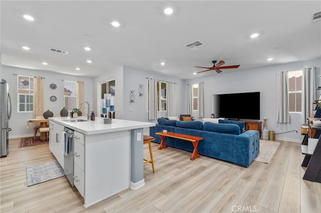 8234 Traveller St, Chino, CA 91710 - kitchen featuring appliances with stainless steel finishes, a center island with sink, light wood-type flooring, light countertops, and recessed lighting