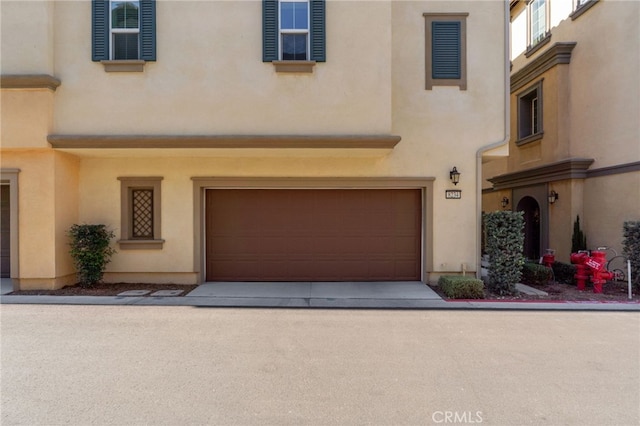 8234 Traveller St, Chino, CA 91710 - view of front of property with stucco siding, a garage, and concrete driveway