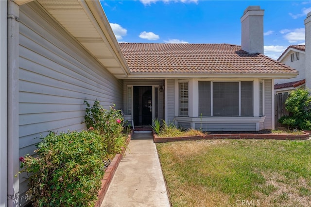 22533 Kinross Ln, Moreno Valley, CA 92557 - entrance to property featuring a tiled roof, a lawn, and a chimney