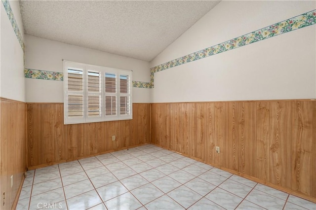 22533 Kinross Ln, Moreno Valley, CA 92557 - empty room featuring a wainscoted wall, wooden walls, a textured ceiling, and lofted ceiling