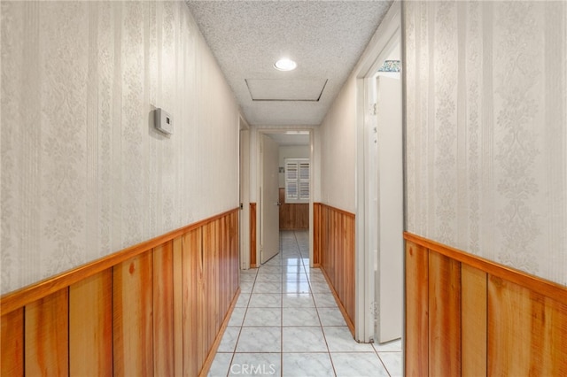22533 Kinross Ln, Moreno Valley, CA 92557 - corridor with a textured ceiling, attic access, wainscoting, wallpapered walls, and light tile patterned floors