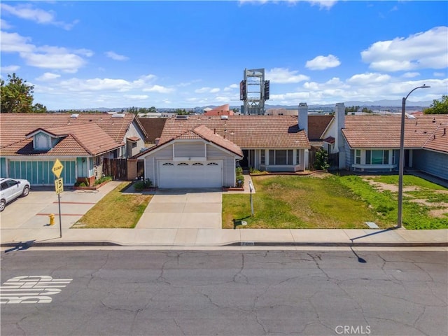 22533 Kinross Ln, Moreno Valley, CA 92557 - mediterranean / spanish-style house featuring a tile roof, driveway, a front lawn, a garage, and a residential view