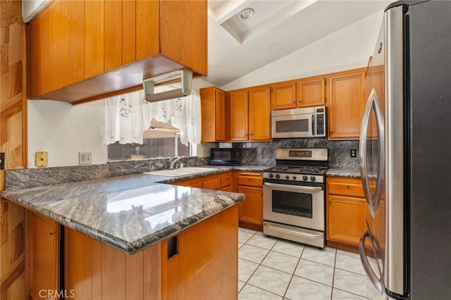 22533 Kinross Ln, Moreno Valley, CA 92557 - kitchen featuring appliances with stainless steel finishes, a peninsula, brown cabinets, lofted ceiling, and backsplash