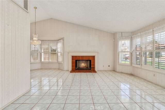 22533 Kinross Ln, Moreno Valley, CA 92557 - unfurnished living room featuring tile patterned flooring, wallpapered walls, a textured ceiling, lofted ceiling, and healthy amount of natural light