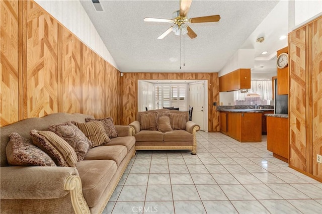 22533 Kinross Ln, Moreno Valley, CA 92557 - living area with ceiling fan, a textured ceiling, wooden walls, vaulted ceiling, and light tile patterned flooring